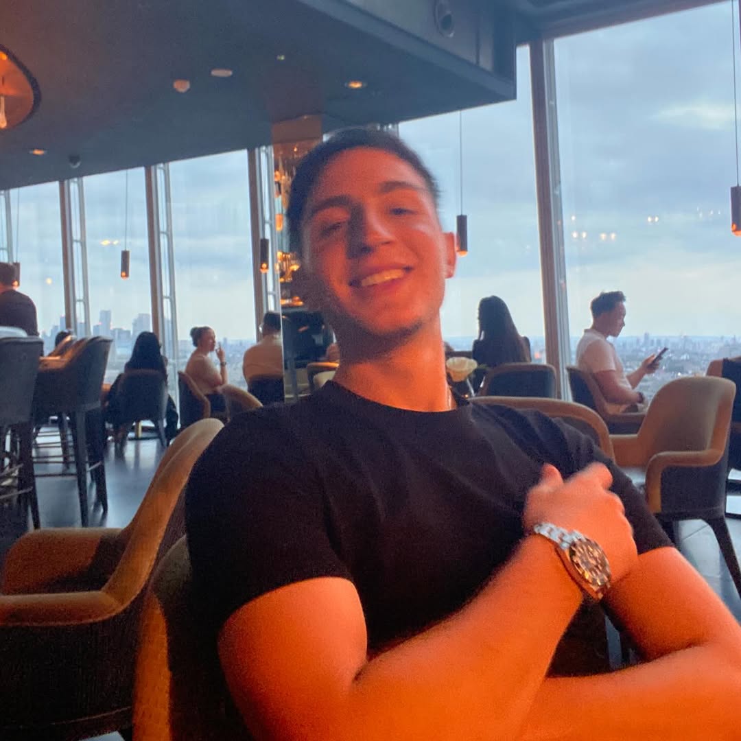 Smiling at a rooftop restaurant with panoramic city views of London